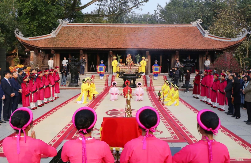 Đội tế nữ quan trong trang phục áo dài, đầu đội khăn kim tuyến, thắt lưng dải lụa, chân đi hài thêu, thực hiện nghi thức tế lễ truyền thống. Ảnh: Trung Kiên - TTXVN