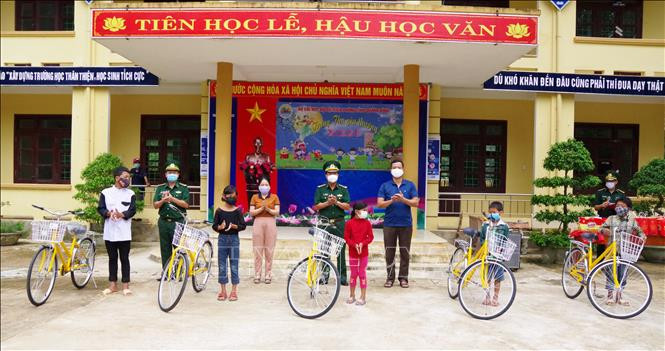 Đại diện lãnh đạo Bộ Chỉ huy Bộ đội Biên phòng Quảng Bình trao tặng xe đạp cho học sinh có hoàn cảnh đặc biệt khó khăn ở Trường Phổ thông dân tộc bán trú THCS Trường Sơn (huyện Quảng Ninh, Quảng Bình). Ảnh: TTXVN phát