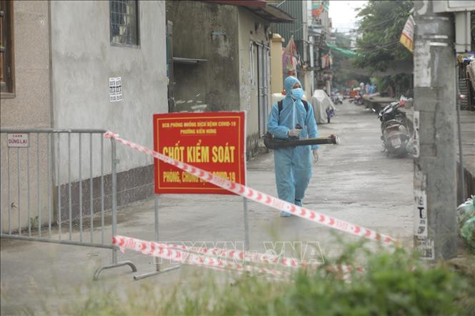 Nhân viên y tế phun khử khuẩn khu vực ngõ, nơi ở của 2 bệnh nhân F0 tại Tổ 8, phường Kiến Hưng. Ảnh: Minh Quyết – TTXVN