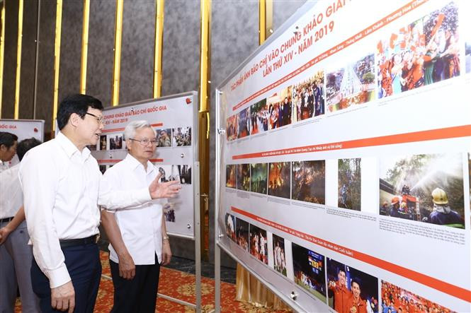 Thành viên Hội đồng giám khảo Giải báo chí quốc gia lần thứ XIV - năm 2019 xem các tác phẩm ảnh báo chí vòng chung khảo. Ảnh: Minh Quyết - TTXVN