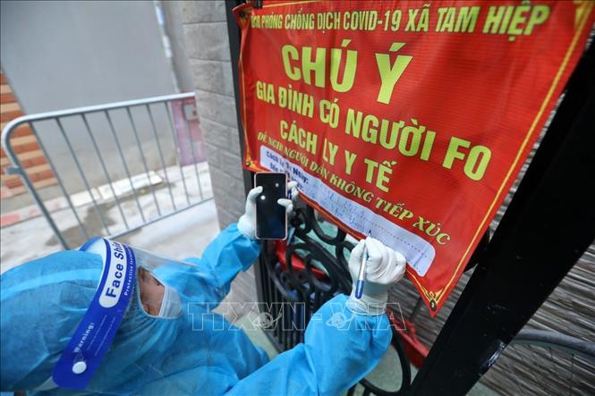 Nhân viên y tế đến nhà bệnh nhân F0 điều trị tại nhà. Ảnh: Minh Quyết – TTXVN