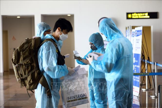 Kiểm tra các giấy xét nghiệm của các hành khách. Ảnh: Huy Hùng - TTXVN