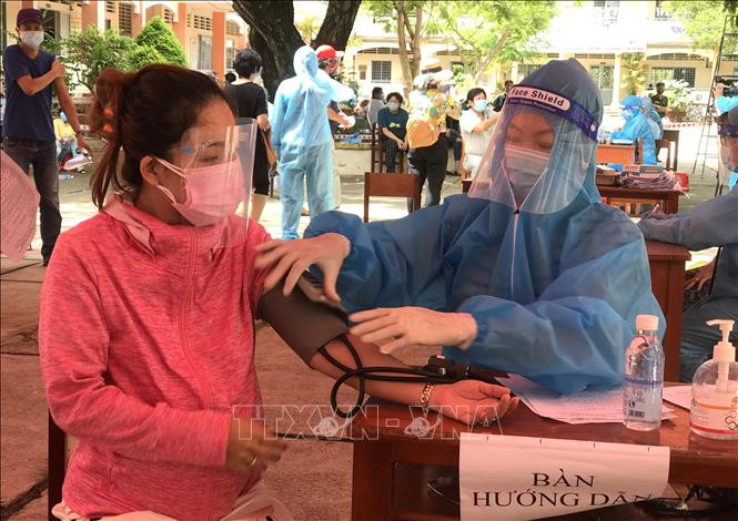 Kiểm tra sức khỏe trước khi tiêm tại điểm tiêm ở thị trấn Trà Ôn (Trà Ôn, Vĩnh Long). Ảnh: Lê Thúy Hằng - TTXVN