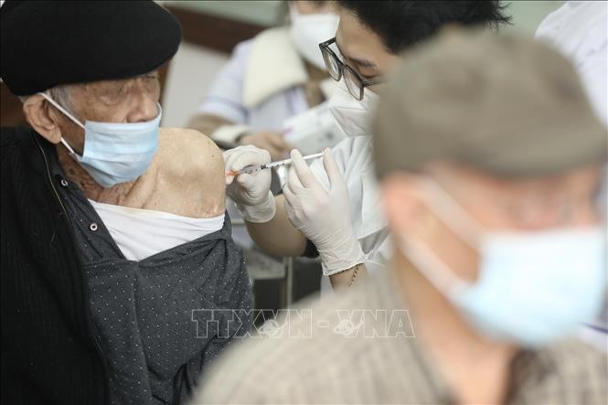 Nhân viên y tế tiêm vaccine phòng COVID-19 cho người cao tuổi phường Lê Đại Hành (quận Hai Bà Trưng), sáng 26/2/2022. Ảnh: Minh Quyết - TTXVN