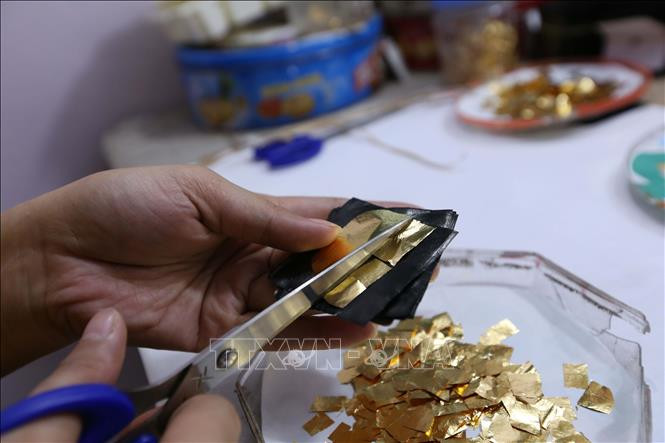 Vàng sau khi cán mỏng được cắt thành miếng nhỏ để “đập quỳ”. Ảnh: Hoàng Hiếu – TTXVN