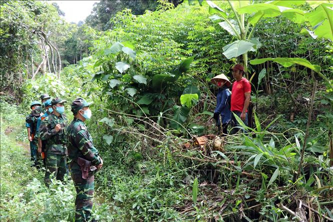 Cán bộ, chiến sĩ Chốt kiểm soát dịch bệnh số 1, Đồn Biên phòng Hương Nguyên (huyện A Lưới) tuyên truyền cho người dân xã A Roàng không được qua lại biên giới trái phép. Ảnh: Đỗ Trưởng-TTXVN
