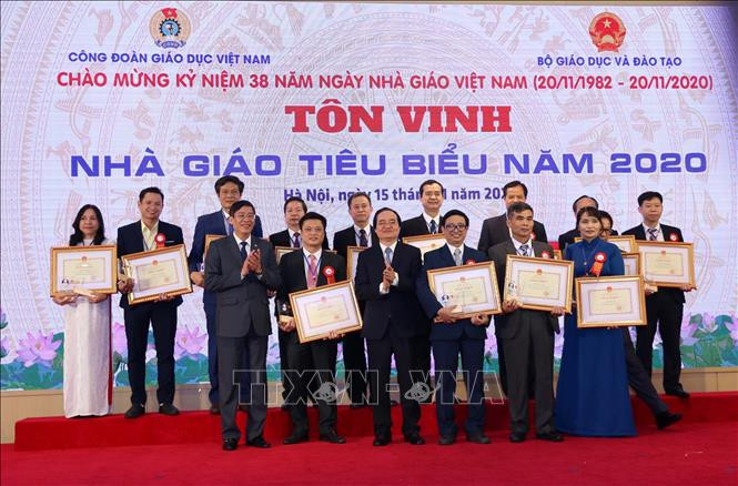 Bộ trưởng Bộ Giáo dục và Đào tạo Phùng Xuân Nhạ và Chủ tịch Công đoàn giáo dục Việt Nam Vũ Minh Đức trao Bằng khen cho các nhà giáo tiêu biểu. Ảnh: Hoàng Hiếu – TTXVN