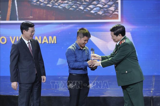 Đồng chí Võ Văn Thưởng, Uỷ viên Bộ Chính trị, Trưởng Ban Tuyên giáo Trung ương, đồng chí Ngô Xuân Lịch, Uỷ viên Bộ Chính trị, Bộ trưởng Bộ Quốc Phòng trao giải Nhất cho tác giả đoạt giải. Ảnh: Minh Quyết – TTXVN