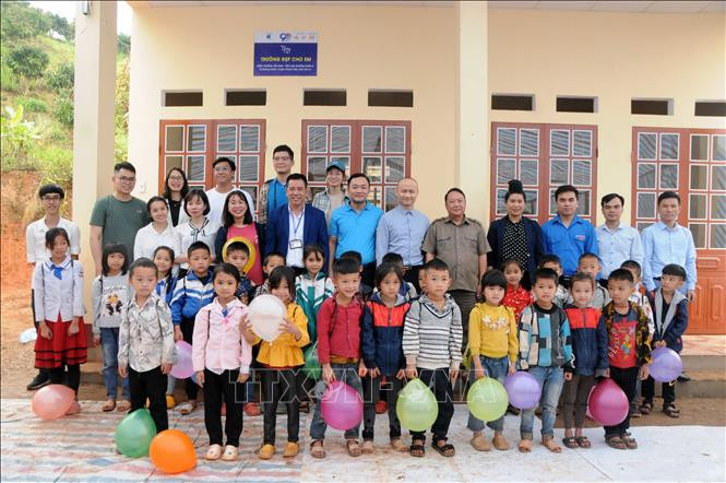 Lãnh đạo Tỉnh đoàn Sơn La và huyện Thuận Châu cùng các nhà tài trợ tặng quà cho các em học sinh trường Tiểu học Mường Khiêng 1 và 2. Ảnh: Quang Quyết-TTXVN