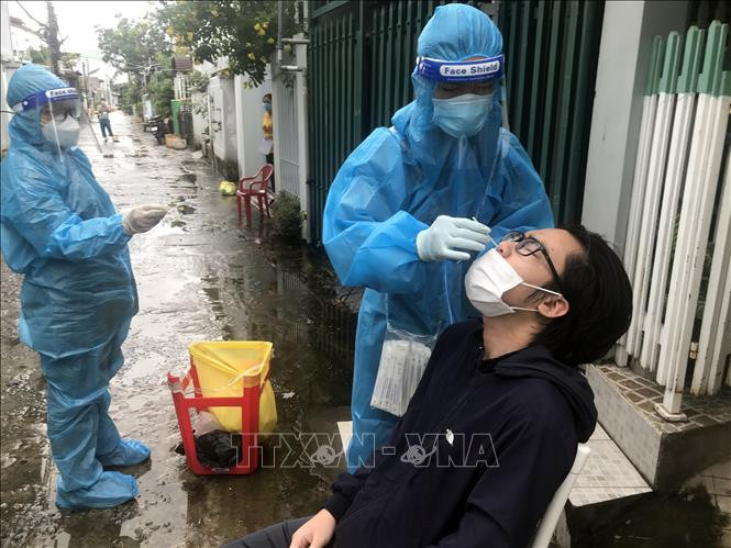 Đội lấy mẫu phường Vĩnh Quang, thành phố Rạch Giá, đến từng hộ dân để thực hiện xét nghiệm sàng lọc SARS-CoV-2. Ảnh: Lê Sen - TTXVN