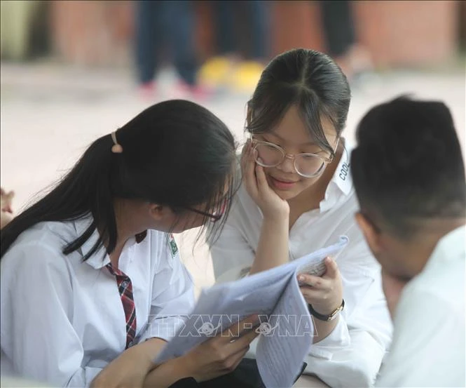 Thí sinh tranh thủ ôn lại kiến thức trước khi vào phòng thi. Ảnh: Thanh Tùng – TTXVN