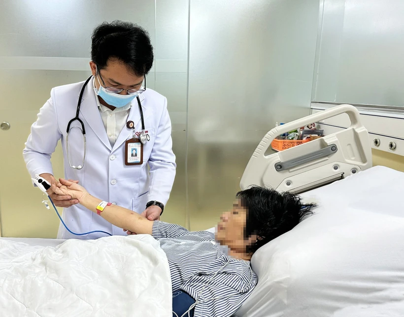 Bác sĩ Bệnh viện Đa khoa Thanh Vũ Medic Bạc Liêu kiểm tra vết ong đốt trên tay bệnh nhân T.H.C. Ảnh: TTXVN phát