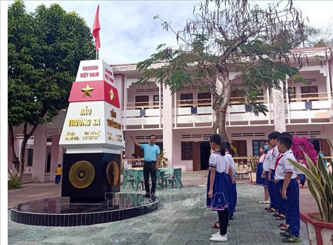 Giáo viên trường Tiểu học – Thực hành Sư phạm Ngụy Như Kon Tum giảng dạy về lịch sử, địa lý cho các em học sinh thông qua cột mốc chủ quyền biển đảo được xây dựng ngay trong sân trường. Ảnh: Khoa Chương – TTXVN