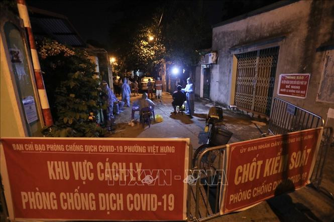 Nhân viên y tế lấy mẫu cho người dân tổ 4, phường Việt Hưng tối 19/9/2021. Ảnh: Minh Quyết - TTXVN