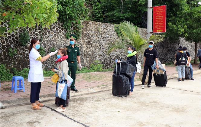 Các lưu học sinh Lào được kiểm tra thân nhiệt trước khi nhập cảnh tại cửa khẩu Chiềng Khương, tỉnh Sơn La. Ảnh: Hữu Quyết - TTXVN