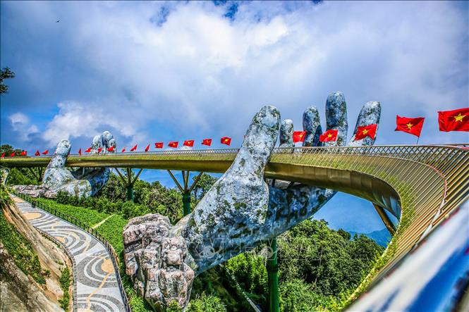 Cầu Vàng rực rỡ cờ Tổ quốc chào đón người dân và du khách trở lại tham quan, du lịch sau dịch COVID-19. Ảnh: Trần Lê Lâm - TTXVN