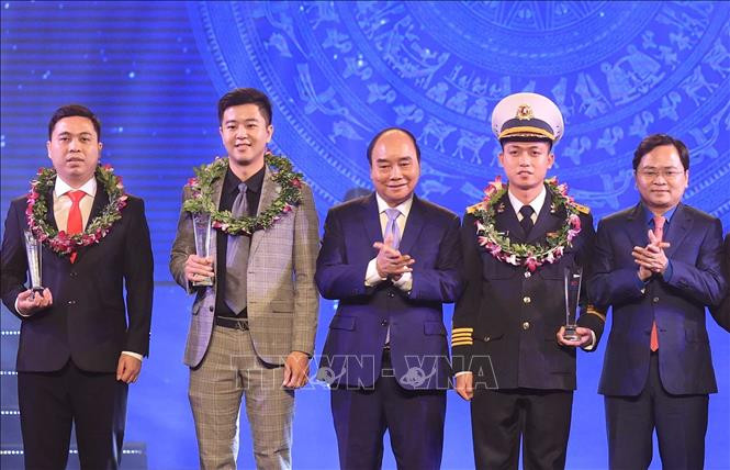 Chủ tịch nước Nguyễn Xuân Phúc và Bí thư thứ nhất TƯ Đoàn Nguyễn Anh Tuấn trao biểu trưng tuyên dương các Gương mặt trẻ Việt Nam tiêu biểu năm 2021. Ảnh: Thống Nhất – TTXVN