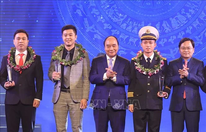 Chủ tịch nước Nguyễn Xuân Phúc và Bí thư thứ nhất TƯ Đoàn Nguyễn Anh Tuấn trao biểu trưng tuyên dương các Gương mặt trẻ Việt Nam tiêu biểu năm 2021. Ảnh: Thống Nhất – TTXVN