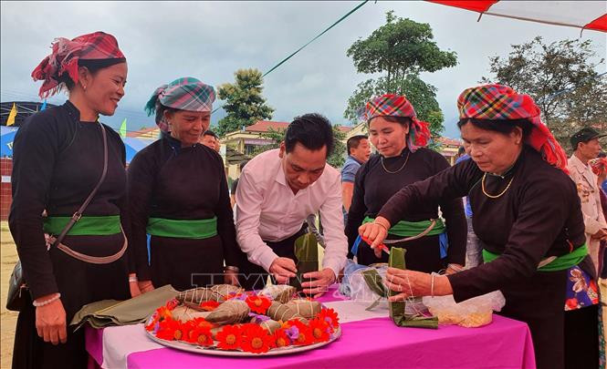 Đại biểu cùng bà con thôn Bo gói bánh trưng tại ngày hội. Ảnh: Quốc Khánh – TTXVN