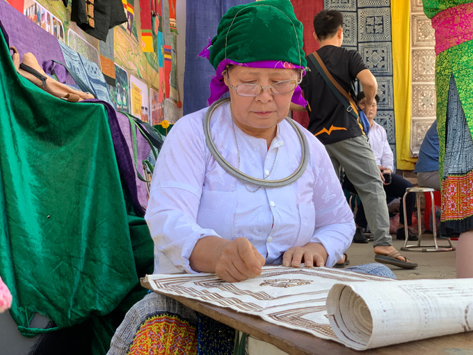 Ảnh 3 Đôi bàn tay khéo léo của người phụ nữ Mông bên công đoạn vẽ sáp ong trên vải lanh được làm thủ công từ cây lanh, một loại cây không thể thiếu trong đời sống của đồng bào dân tộc Mông.JPG