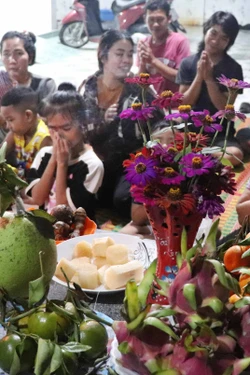 Nghi thức đút cốm dẹp cho con cháu và các thành viên trong gia đình.