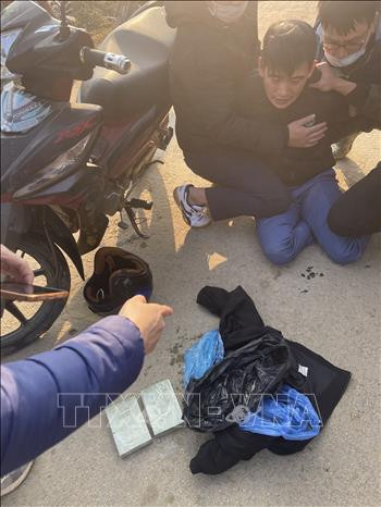 Bắt giữ đối tượng cùng hai bánh heroin. Ảnh: TTXVN phát Lào Cai triệt phá chuyên án ma túy, bắt 1 đối tượng, thu giữ 2 bánh heroin ảnh 2
