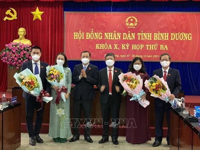 Ông Võ Văn Minh (thứ 4 từ trái qua), Phó Bí thư Tỉnh ủy, Chủ tịch UBND tỉnh và ông Phạm Văn Chánh (thứ 3 từ trái qua), Ủy viên Ban Thường vụ Tỉnh ủy, Chủ tịch HĐND tỉnh tặng hoa chúc mừng các đồng chí vừa trúng cử. Ảnh: TTXVN phát Ông Nguyễn Văn Dành được bầu làm Phó Chủ tịch UBND tỉnh Bình Dương ảnh 1