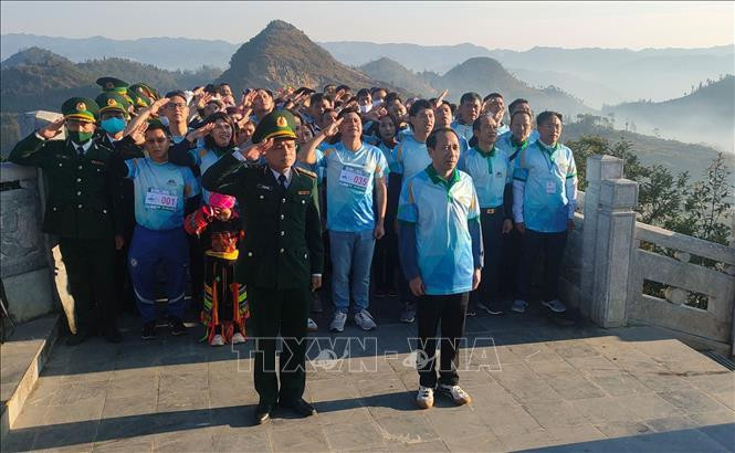 Các vận động viên tham ra Giải Marathon “Hành trình về cực Bắc” thực hiện nghi lễ chào cờ dưới chân cột cờ Lũng Cú, xã Lũng Cú, huyện Đồng Văn (Hà Giang) Ảnh: Nguyễn Chiến - TTXVN Ấn tượng Giải Marathon “Hành trình về cực Bắc” ảnh 3