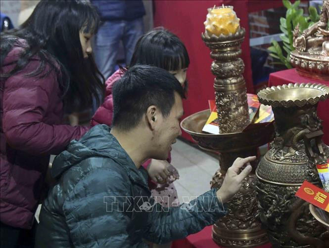 Khách tham quan sản phẩm đúc đồng của làng nghề Ngũ Xã. Ảnh: Tuấn Đức - TTXVN Lễ hội Văn hóa dân gian trong đời sống đương đại tại Hà Nội ảnh 2