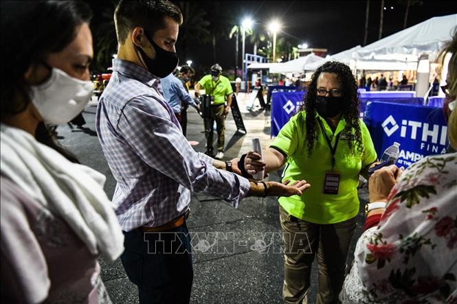 Khán giả được kiểm tra thân nhiệt phòng lây nhiễm COVID-19 trước khi xem vở "La Boheme" trong chuỗi chương trình hòa nhạc opera do công ty Palm Beach Opera (Florida, Mỹ) tổ chức ngày 19/2/2021. Ảnh: AFP/TTXVN Độc đáo lễ hội âm nhạc ngoài trời Palm Beach Opera ảnh 1