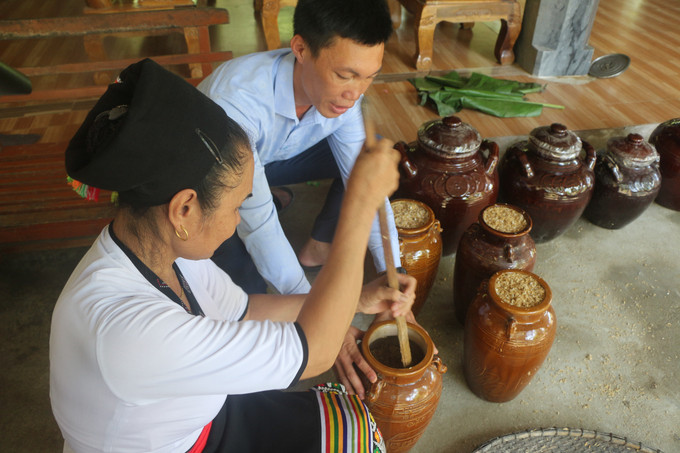 Cho các nguyên liệu vào bình sành, sứ để ủ. Ảnh: Bích Huệ - TTXVN Phát triển sản phẩm OCOP chậm mà chắc ảnh 3