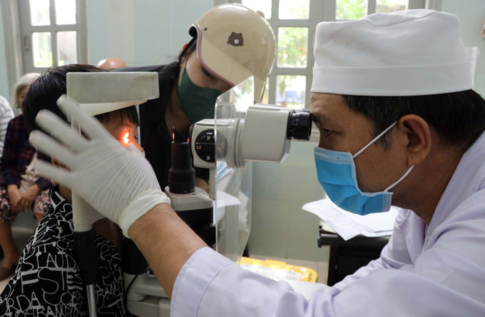 Bác sĩ Bệnh viện Mắt tỉnh Ninh Thuận khám cho trẻ bị đau mắt đỏ. Ảnh: Công Thử - TTXVN Ninh Thuận giám sát, phát hiện sớm, xử lý kịp thời bệnh đau mắt đỏ ảnh 2
