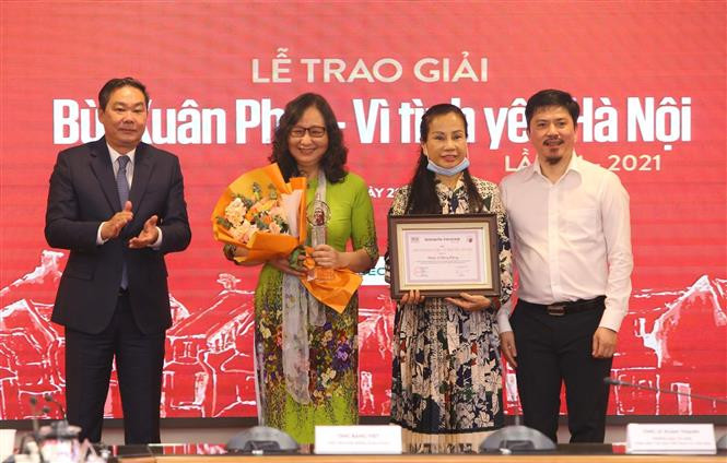 Phó Chủ tịch Thường trực UBND Thành phố Hà Nội Lê Hồng Sơn (bên trái) và Tổng Biên tập Báo Thể thao và Văn hoá Lê Văn Thành trao “Giải thưởng lớn - Vì tình yêu Hà Nội” cho đại diện gia đình nhạc sỹ Hồng Đăng. Ảnh: Hoàng Hiếu - TTXVN Giải Bùi Xuân Phái – Vì tình yêu Hà Nội: Tôn vinh nhạc sỹ Hồng Đăng ở Giải thưởng Lớn ảnh 2