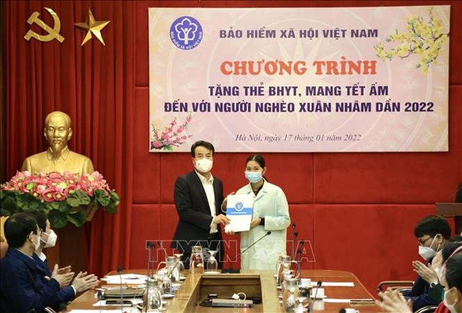 Tổng Giám đốc Bảo hiểm xã hội Việt Nam Nguyễn Thế Mạnh tặng quà bệnh nhân và người nhà bệnh nhân. Ảnh: TTXVN phát Tặng gần 600 sổ bảo hiểm xã hội, hơn 10 nghìn thẻ bảo hiểm y tế và trên 3.000 phần quà tới người dân có hoàn cảnh khó khăn ảnh 1
