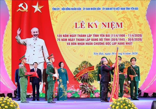 Thường trực Ban Bí thư Trần Quốc Vượng gắn Huân chương Độc lập hạng Nhất lên lá cờ truyền thống của tỉnh Yên Bái. Ảnh: Tuấn Anh - TTXVN Kỷ niệm trọng thể 120 năm Ngày thành lập tỉnh Yên Bái ảnh 3