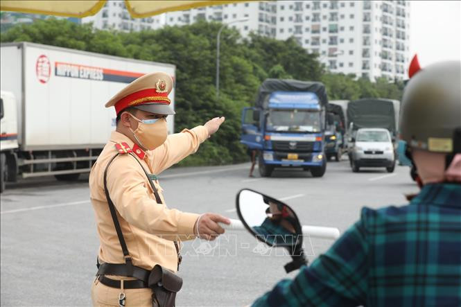 Lực lượng chức năng hướng dẫn các chủ phương tiện cho xe quay đầu tại chốt số 5 (cầu Phù Đổng, huyện Gia Lâm) (ảnh chụp 7h30, ngày 24/7/2021). Ảnh: Minh Quyết - TTXVN Dịch COVID-19: Hà Nội tận dụng tối đa 15 ngày giãn cách để trở lại trạng thái bình thường ảnh 2
