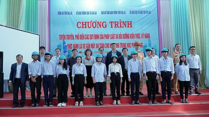 Ban tổ chức trao tặng 145 mũ bảo hiểm cho học sinh người dân tộc thiểu số. Ảnh: Hoài Nam – TTXVN Gia Lai nâng cao ý thức lái xe gắn máy an toàn cho học sinh trung học phổ thông ảnh 3