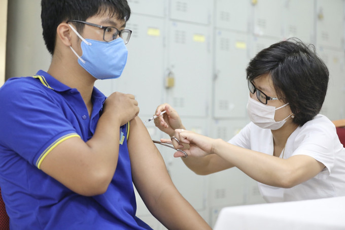 Nhân viên y tế tiêm vaccine phòng COVID-19 cho nhóm tuổi từ 12-17 tại điểm tiêm trường THPT Việt Đức (Hoàn Kiếm, Hà Nội). Ảnh: Minh Quyết - TTXVN Trong ngày 4/8, cả nước có thêm 7.712 bệnh nhân COVID-19 được điều trị khỏi ảnh 1