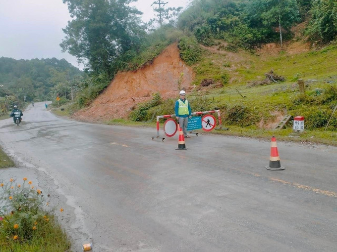 Lực lượng chức năng cắm biển cảnh báo cho các phương tiện tham gia giao thông. Ảnh: TTXVN phát Hà Tĩnh: Mưa lớn gây sạt lở đất đá, ách tắc trên Quốc lộ 8A ảnh 2