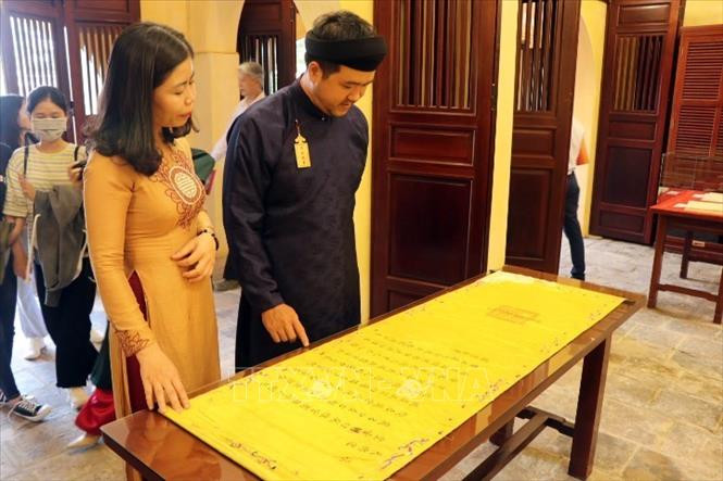 Du khách tham quan hiện vật trưng bày tại không gian Tàng Thơ Lâu. Ảnh: Đỗ Trưởng - TTXVN Thừa Thiên – Huế: Khai trương không gian Tàng Thơ Lâu và giới thiệu thư tịch triều Nguyễn ảnh 1