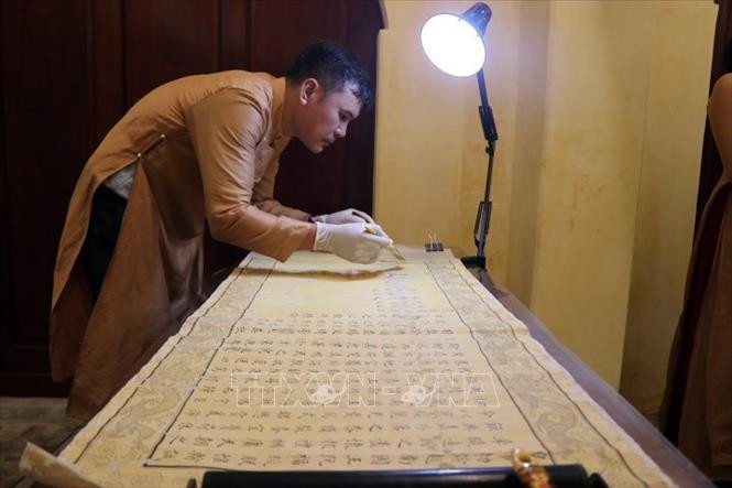 Phục hồi sắc phong triều Nguyễn tại không gian Tàng Thơ Lâu. Ảnh: Đỗ Trưởng - TTXVN Thừa Thiên – Huế: Khai trương không gian Tàng Thơ Lâu và giới thiệu thư tịch triều Nguyễn ảnh 3