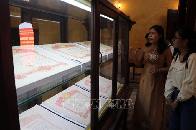 Du khách tham quan hiện vật trưng bày tại không gian Tàng Thơ Lâu. Ảnh: Đỗ Trưởng - TTXVN Thừa Thiên – Huế: Khai trương không gian Tàng Thơ Lâu và giới thiệu thư tịch triều Nguyễn ảnh 2