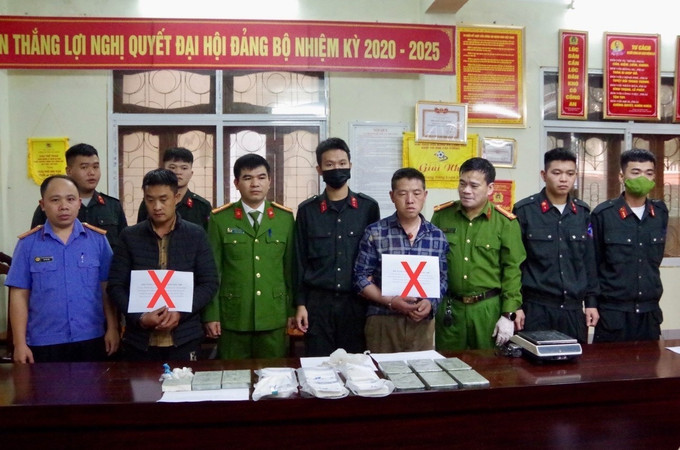 Hai đối tượng Thào Ly Pó và Vàng Mí Co (đánh dấu X) cùng số tang vật 15 bánh heroin bị bắt giữ. Ảnh: TTXVN phát Bắt 2 đối tượng Thào Ly Pó và Vàng Mí Co tàng trữ, vận chuyển 15 bánh heroin ảnh 1