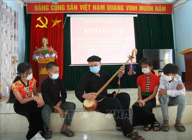 Nghệ nhân Lò Văn Sơi, Câu lạc bộ hát then - đàn tính xã Mường Cang hướng dẫn các em học sinh học kỹ năng sử dụng đàn tính của dân tộc Thái. Ảnh: Đinh Thùy-TTXVN Huyện Than Uyên bảo tồn giá trị văn hóa gắn với phát triển du lịch ảnh 1
