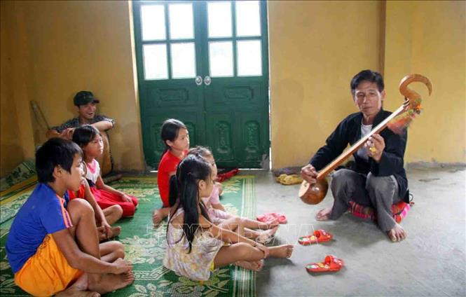 Nghệ nhân Câu lạc bộ hát then - đàn tính ở xã Hua Nà dạy các em nhỏ học về kỹ năng sử dụng đàn tính. Ảnh: Đinh Thùy-TTXVN Huyện Than Uyên bảo tồn giá trị văn hóa gắn với phát triển du lịch ảnh 2
