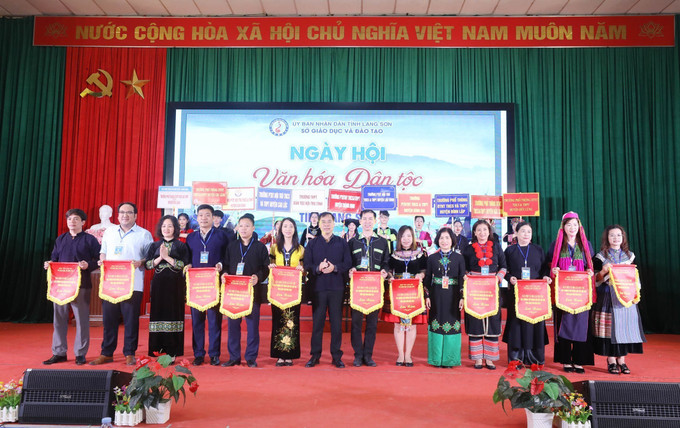 Các đoàn dự thi của các trường nhận cờ lưu niệm tại lễ Khai mạc. Ảnh: Anh Tuấn – TTXVN Tạo sân chơi bổ ích cho học sinh dân tộc thiểu số tỉnh Lạng Sơn ảnh 4