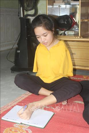 Cô sinh viên năm nhất Y Julie học bài. Ảnh: Khoa Chương – TTXVN Y Julie – Cô gái cụt 2 tay bước chân vào đại học ảnh 2