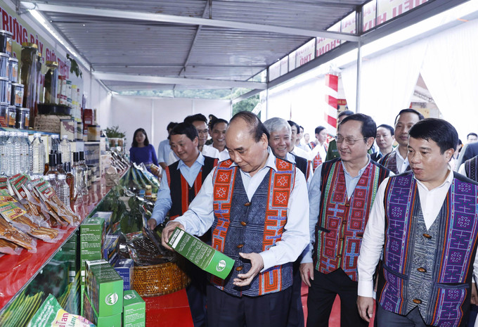 Chủ tịch nước Nguyễn Xuân Phúc tham quan các gian trưng bày sản phẩm OCOP của tỉnh Lai Châu. Ảnh: Thống Nhất - TTXVN Chủ tịch nước Nguyễn Xuân Phúc dự Ngày hội Đại đoàn kết toàn dân tộc tại Phong Thổ, Lai Châu ảnh 5