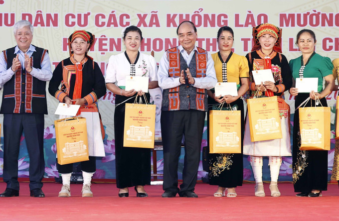 Chủ tịch nước Nguyễn Xuân Phúc tặng quà cho các gia đình tiểu biểu. Ảnh: Thống Nhất - TTXVN Chủ tịch nước Nguyễn Xuân Phúc dự Ngày hội Đại đoàn kết toàn dân tộc tại Phong Thổ, Lai Châu ảnh 4