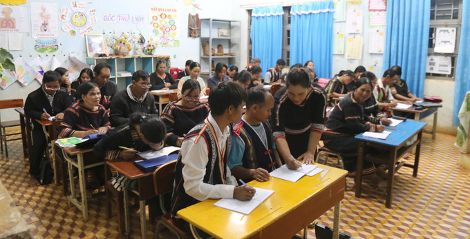 Cô giáo Kso H'Vớt đang chăm chú uốn nắn từng nét chữ cho các học viên. Ảnh: Quang Thái- TTXVN Gia Lai: Lớp học đặc biệt cho học sinh tuổi trung niên ảnh 5